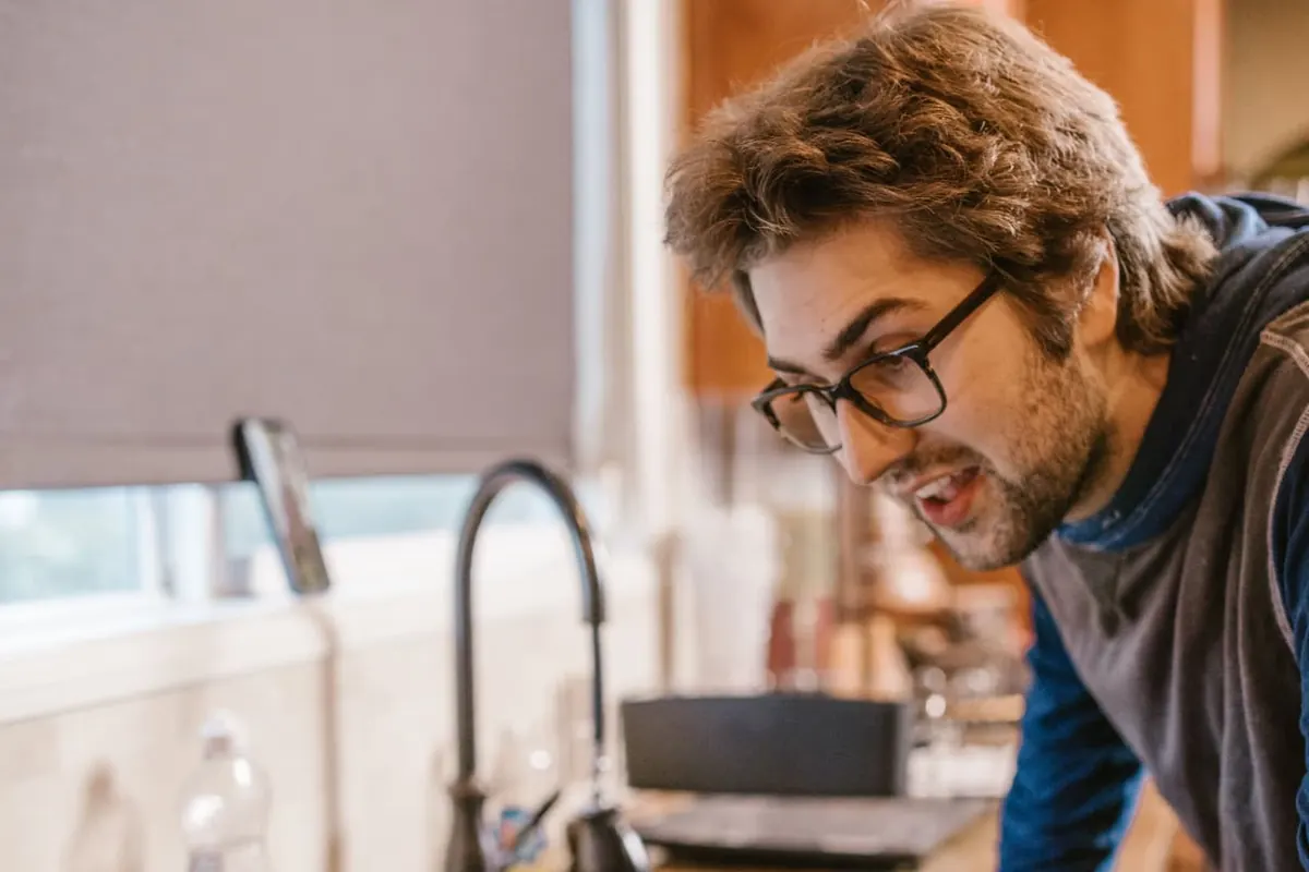 Contractor at a kitchen counter checking his website on a laptop